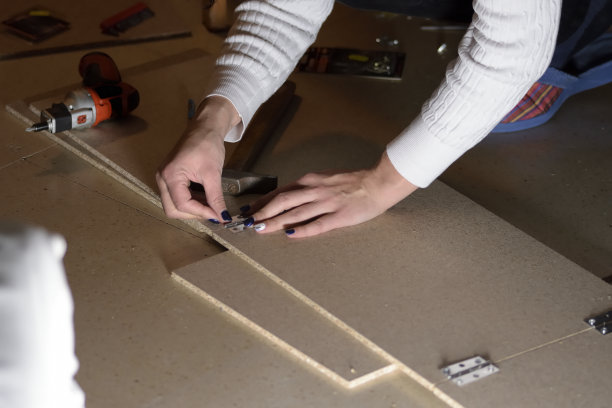 这是一名年轻女子在家用木头做DIY的照片。有选择性的重点图片下载