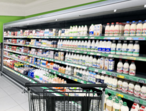 在超市选择乳制品。空空的超市里空空的购物车图片下载