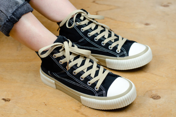 时尚运动鞋对女性的腿特写。那个女人穿着时髦的黑色运动鞋。图片下载