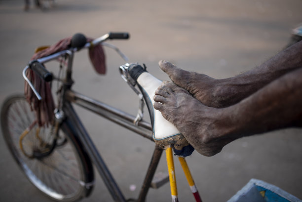 辛苦工作的人力车工人在他的人力车上休息的特写照片图片下载