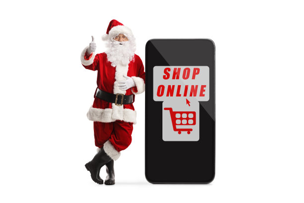 圣诞老人倚靠在智能手机上的全身像，上面有网上商店的标志，并竖起大拇指图片下载
