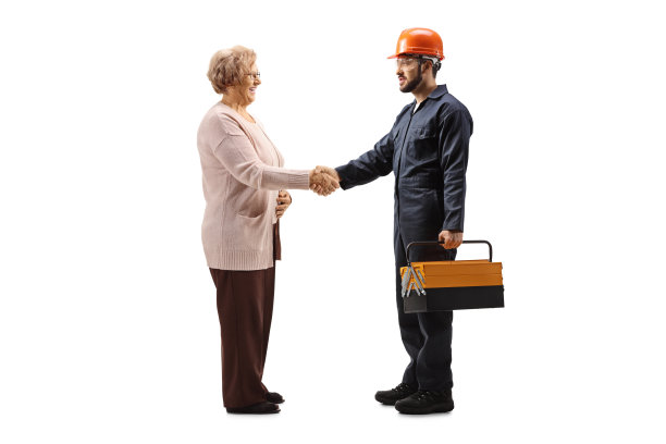 一名工人穿着制服，戴着头盔，与一名老妇人握手图片下载
