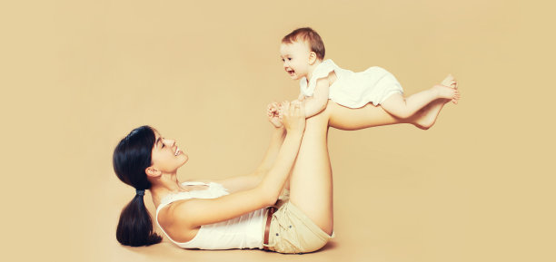 快乐的母亲和宝宝在棕色背景上玩耍图片下载