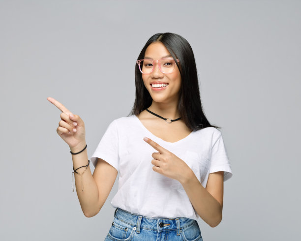 快乐的女人指着灰色的背景图片下载