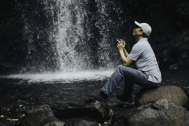 坐在丛林中的亚洲摄影师图片下载