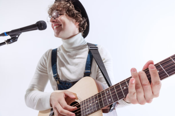 年轻的情感男子肖像，音乐家演奏吉他和唱歌。艺术概念，音乐，风格和创作图片下载