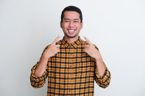 亚洲成年男子露出灿烂的笑容，指着它图片下载