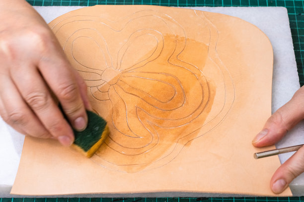 工匠把装饰品弄湿在皮革上图片下载