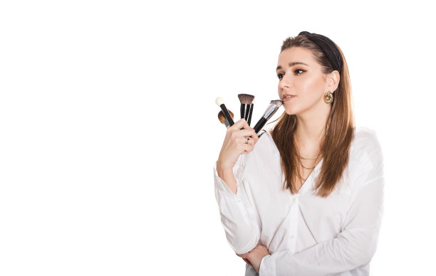 年轻美丽的专业化妆师与化妆刷隔离在白色背景。图片下载