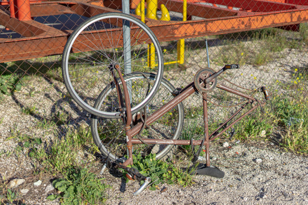 在公共道路上靠在栏杆上的破旧自行车图片下载
