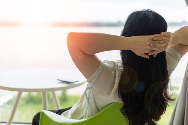 良好的生活和轻松放松的商务女性生活方式工作后，在酒店坐着双手背后的幸福的商业女性的人。简化生活周图片下载