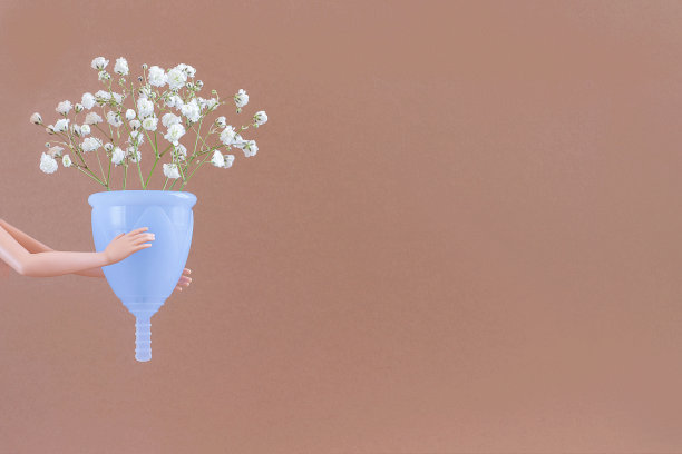 蓝色月经杯和花束精致的花在棕色背景与拷贝空间。女性亲密的卫生。女性健康理念，环保，零浪费替代品图片下载