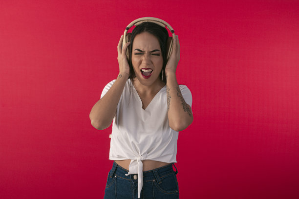 年轻女子与耳机作为DJ和工作室照片的红色背景。图片下载