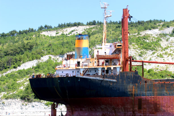 一艘生锈的货船搁浅在海边，被遗弃了。图片下载