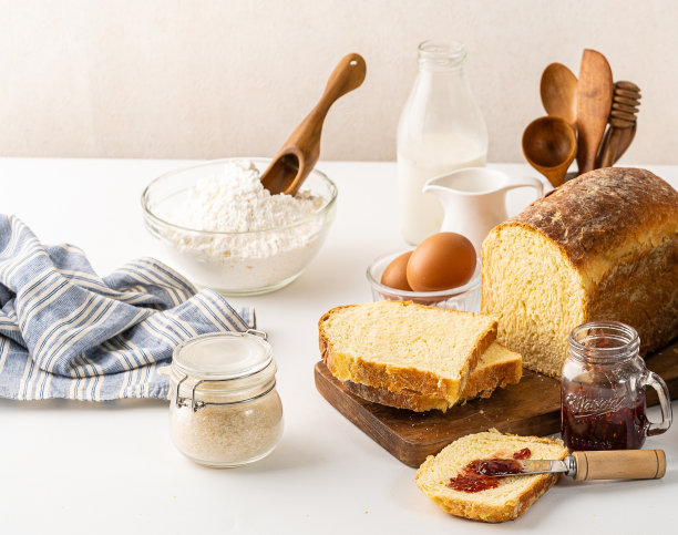 桌上的早餐和食材都是白色的。这种食物由面包、面粉、鸡蛋、巧克力和奶酪组成图片下载
