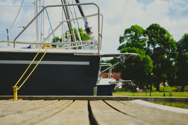 在港口木制码头上停泊的帆船上观看，近距离观看帆船的船体和船首图片下载