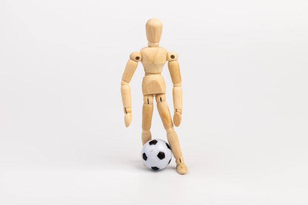 木制假人与足球孤立在白色背景。足球运动员的概念。图片下载