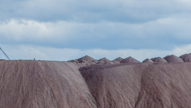 在多云的天空背景下开采钾矿时的空矿山。把一块空石头运到垃圾场。图片下载