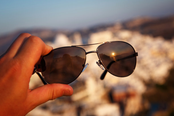 假期的概念。飞行员太阳镜与旅游小镇的背景。图片下载