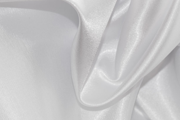 白色褶皱纺织品的特写。图片下载