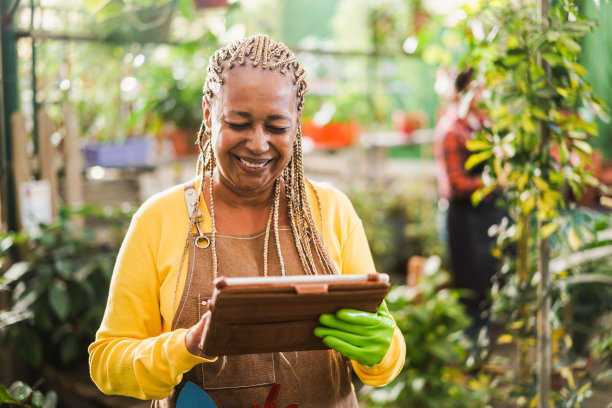 非洲妇女工作在温室花园-苗圃和春天的概念-关注的脸图片下载