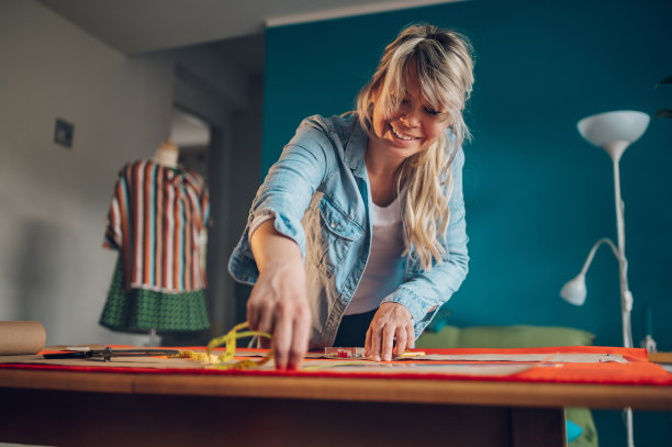 女裁缝在家工作，剪裁漂亮的衣服图片下载