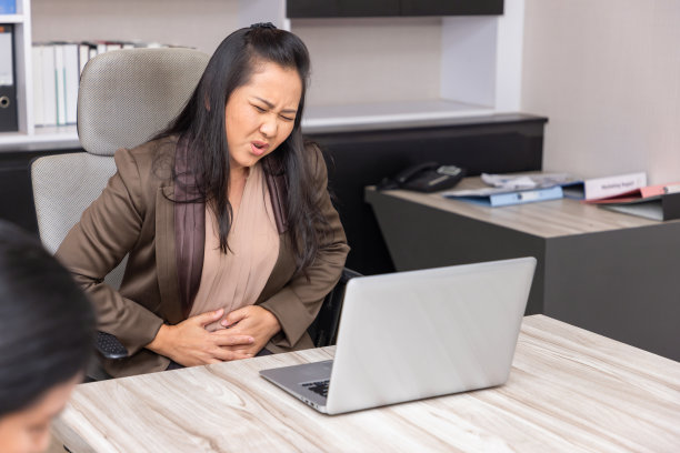 在工作场所遭受胃痛的成熟商人。图片下载