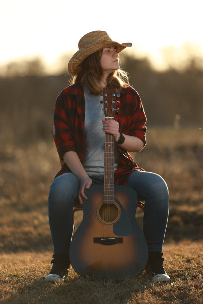 牛仔女郎在日落时弹吉他图片下载