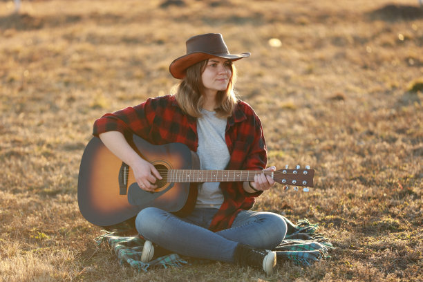 牛仔女郎在日落时弹吉他图片下载