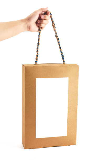 手持牛皮纸手提袋，白色背景隔离图片下载