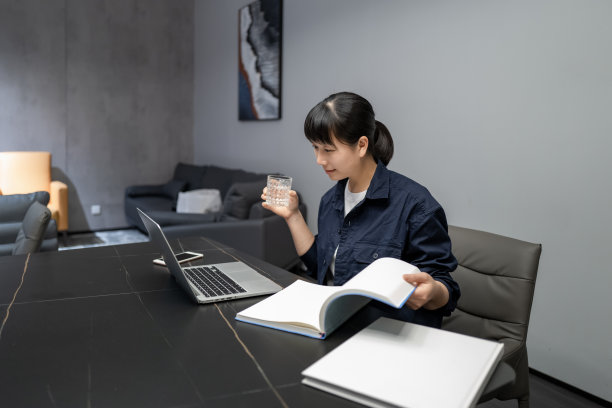 一位中国女经理在学习财务管理知识的缺口中喝水图片下载