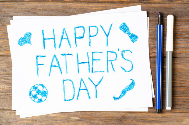 孩子在木桌上画画。父亲节的明信片图片下载