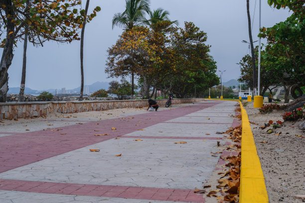 照片上是一条有鹅卵石痕迹的混凝土小路，在寒冷的日子里，尽头是灰色的，中间是红色的图片下载