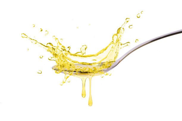 烹饪油溅在不锈钢勺子孤立的白色背景图片下载