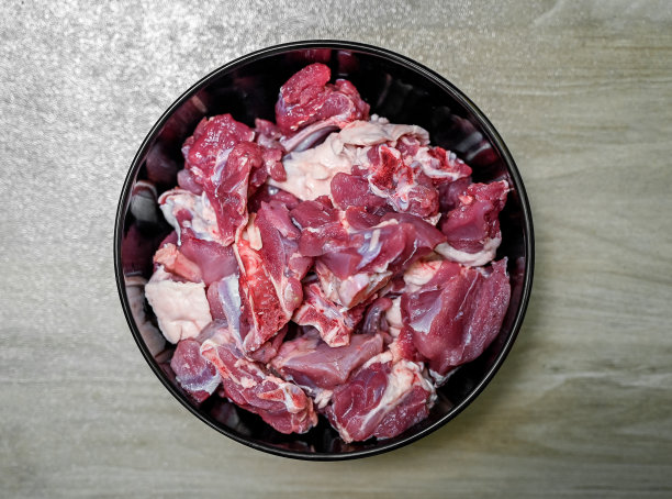 黑色背景上的生肉块，顶视图。分离的生羊肉。图片下载