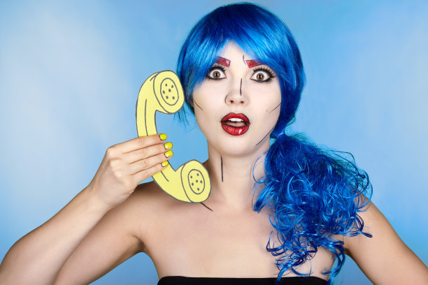 年轻女子肖像在漫画流行艺术化妆风格。蓝色背景下戴蓝色假发的女性打电话图片下载