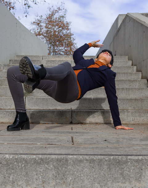 短发女人在台阶中间用一只脚和一只手保持平衡图片下载