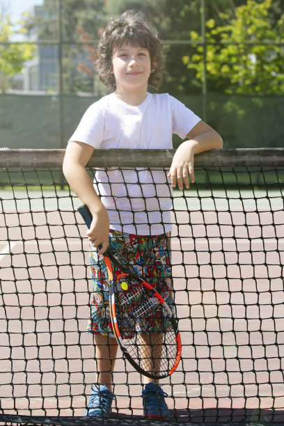 快乐的男孩和朋友在户外打网球图片下载