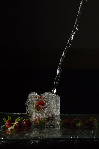 草莓被倒入一杯水花中图片下载