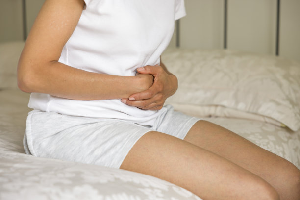 肚子疼，亚洲印度女人抱着肚子疼图片下载