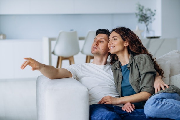 新婚夫妇坐在沙发上讨论未来梦想的计划图片下载