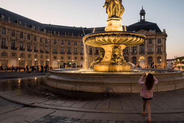 在波尔多的交易所广场拍摄三恩典喷泉的年轻女孩图片下载