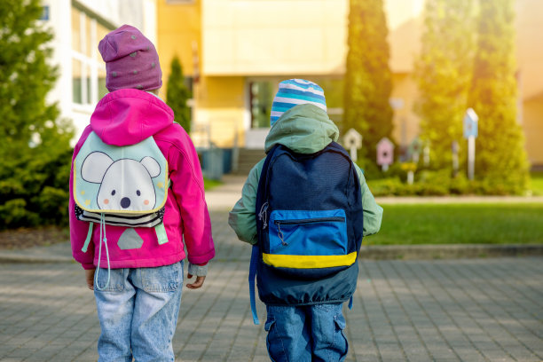 孩子们早上背着书包去上学。后视图图片下载