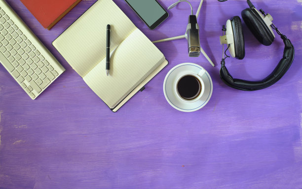 制作播客与时尚耳机，复古麦克风，咖啡，智能手机，电脑键盘在紫色的桌子上。平铺用拷贝空间、负空间手法。图片下载