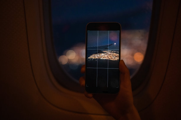 乘客用智能手机通过飞机窗户拍风景照片图片下载
