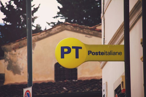 2022年5月9日意大利佛罗伦萨，带有复古教堂背景的“Poste Italiane”街道标志，意大利国家邮政服务概念图片下载