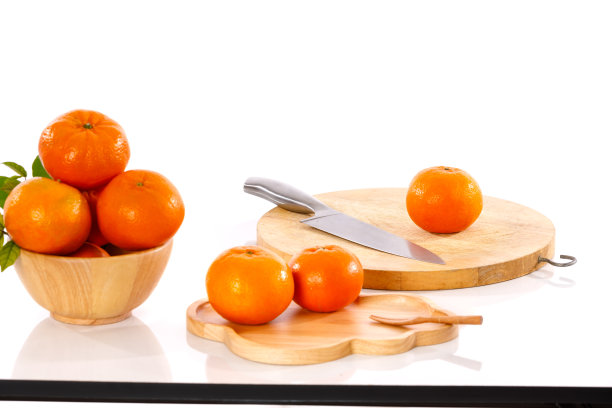 橙色，金色和小刀放在白色的桌子上图片下载