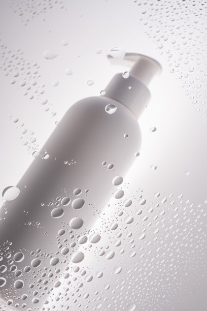 一瓶沐浴露、洗发精或体霜放在滴液的背景上。图片下载