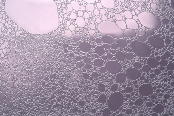 紫色背景上蓬松的白色泡沫。图片下载