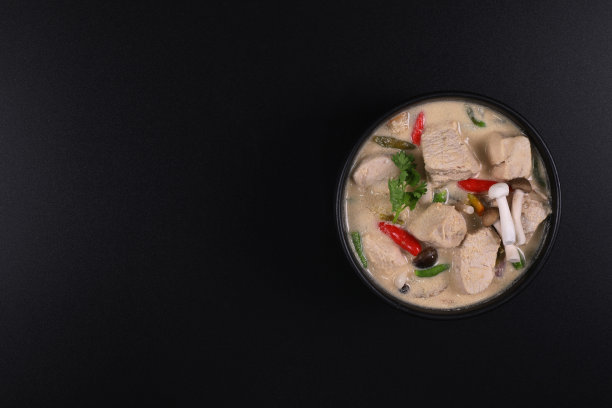 椰汁丐。泰式鸡椰汤碗孤立在一个黑色的背景。俯视图有复制空间。图片下载